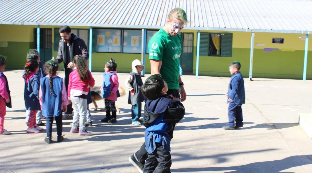 A Projects Abroad volunteer speaking with children in Argentina on our programme for high school students A teenager spends time with children as part of his volunteer work in Argentina